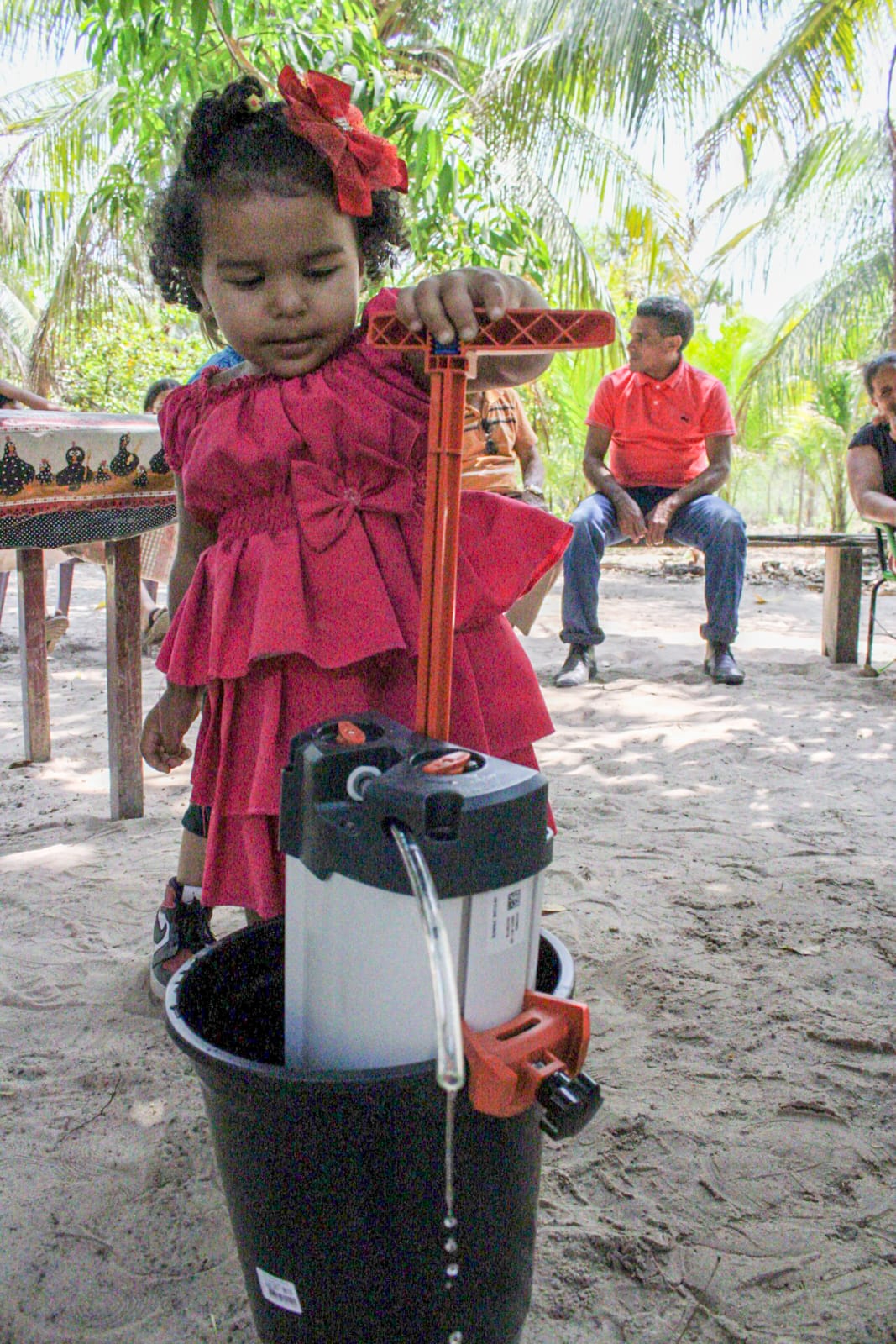 Un enfant utilisant le purificateur d'eau ORISA au Brésil