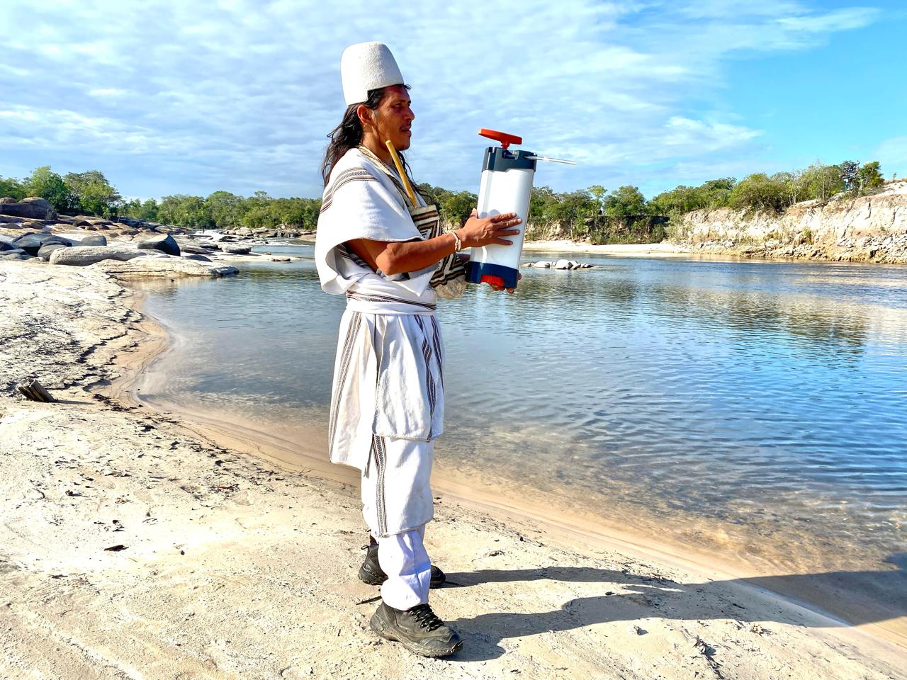 Un indigène Wayuu avec en main le purificateur d'eau ORISA près d'un lac