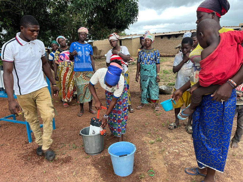 Des bénéficiaires burkinabés filtrent de l'eau avec ORISA grâce au secours islamique France