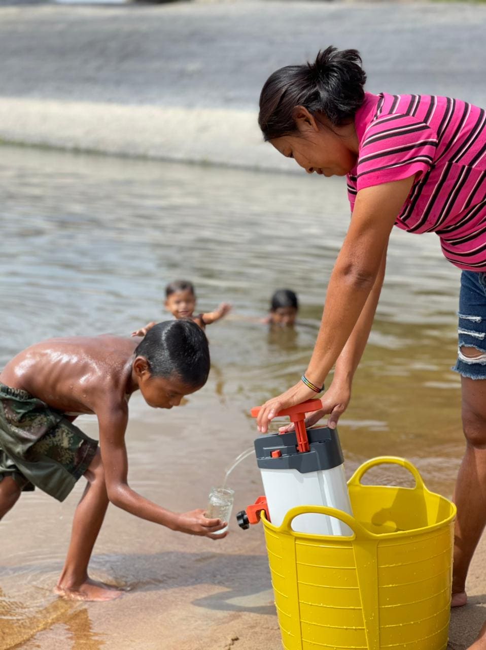 filtration d'eau par une famille en colombie aux abords d'un fleuve