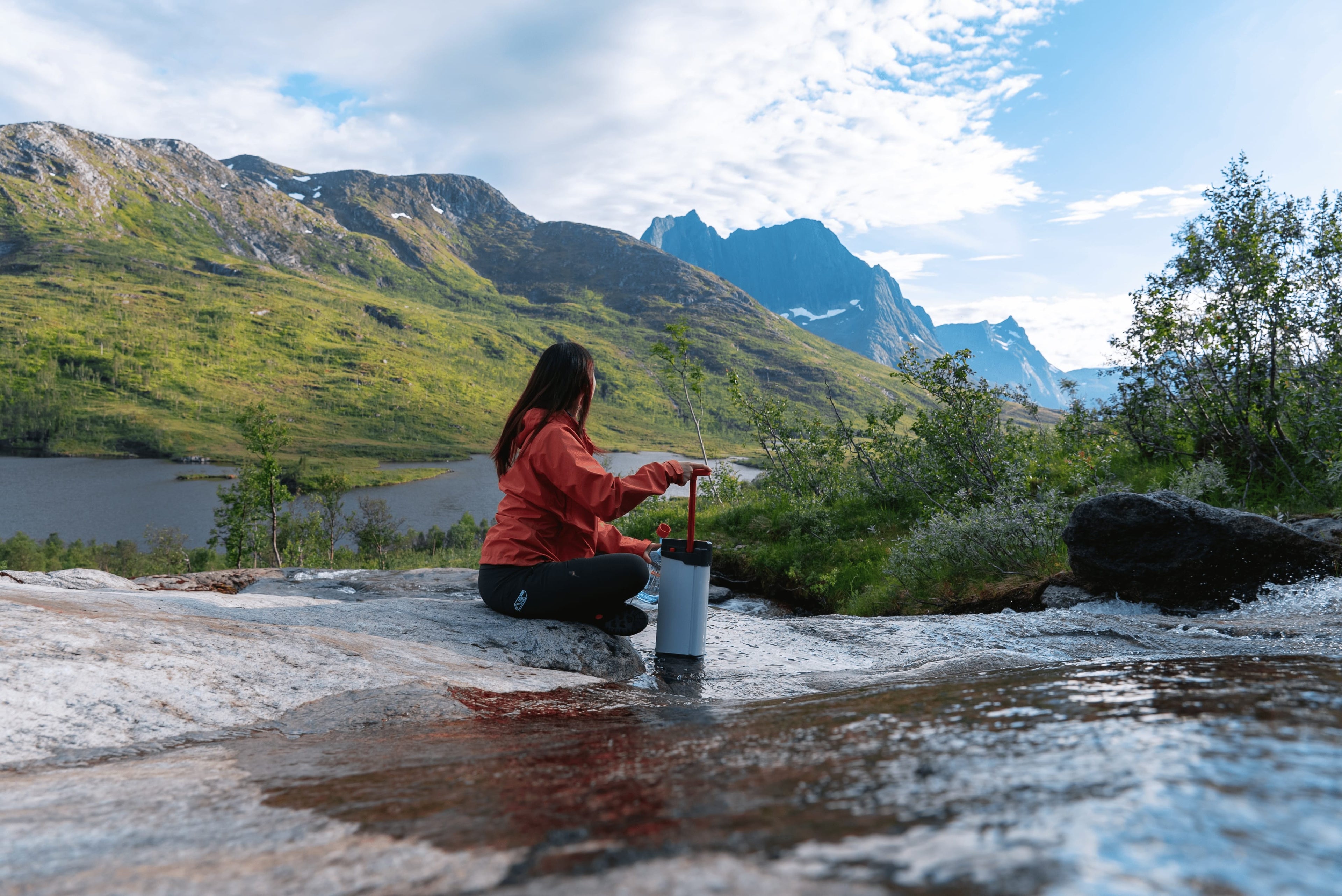 Utilisation du filtre à eau ORISA en pleine nature, au bord d’un ruisseau de montagne, lors d’une randonnée en autonomie