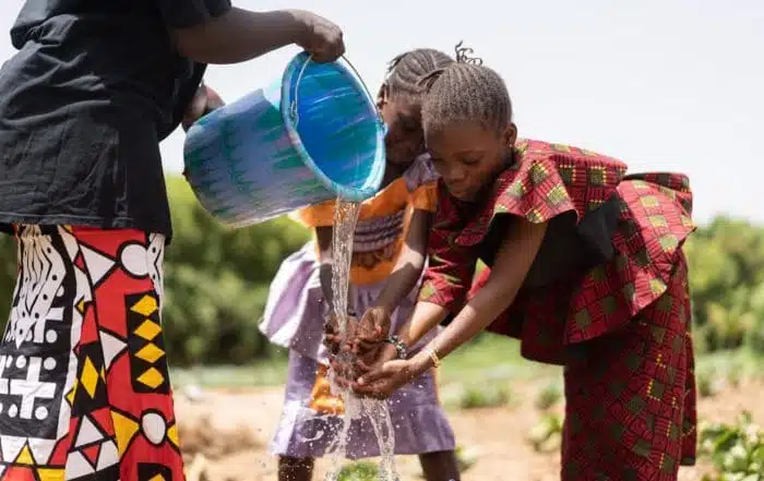 des enfants se nettoient les mains avec de l'eau propre