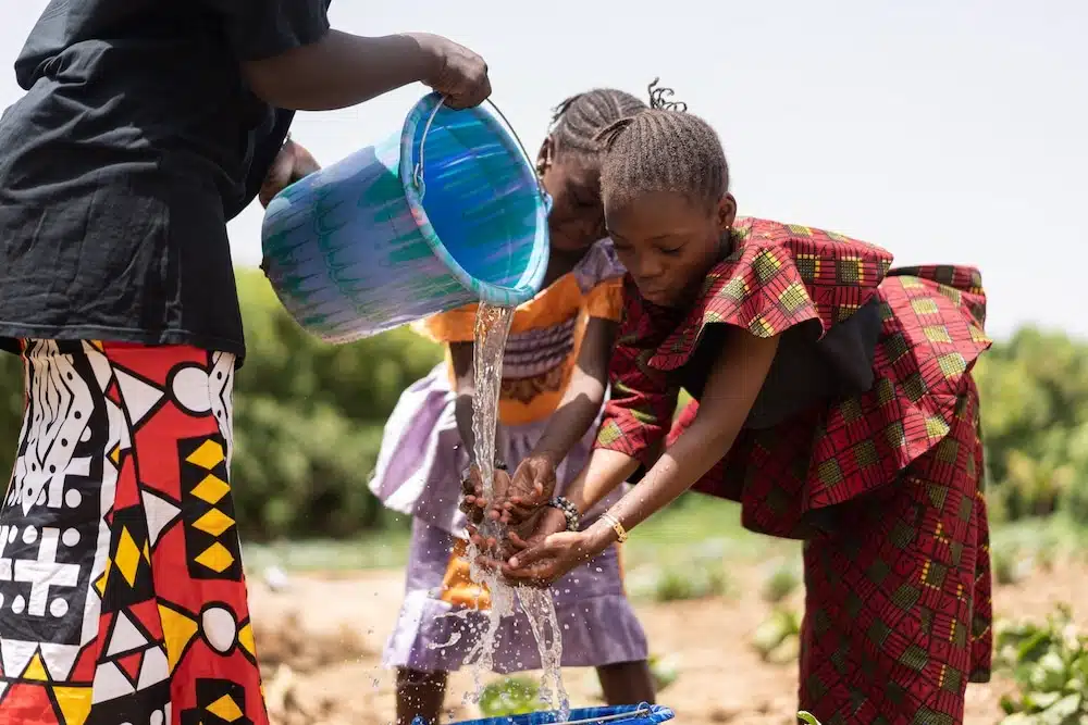 des enfants se nettoient les mains avec de l'eau propre