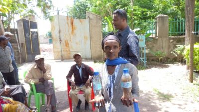 une femme tient deux bouteilles dans ses mains une contenant de l'eau filtrée par le purificateur orisa l'autre de l'eau sale
